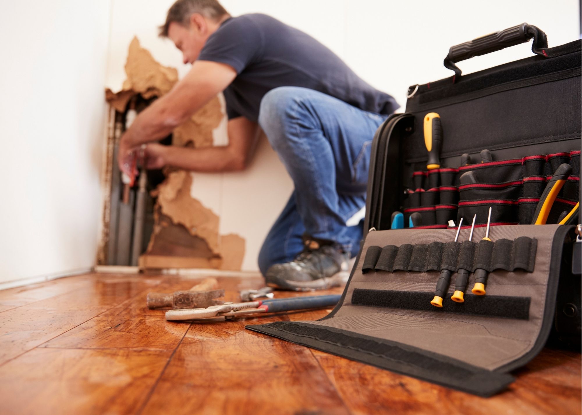 Restoration technician repairing a wall pipe in an Austin, TX home