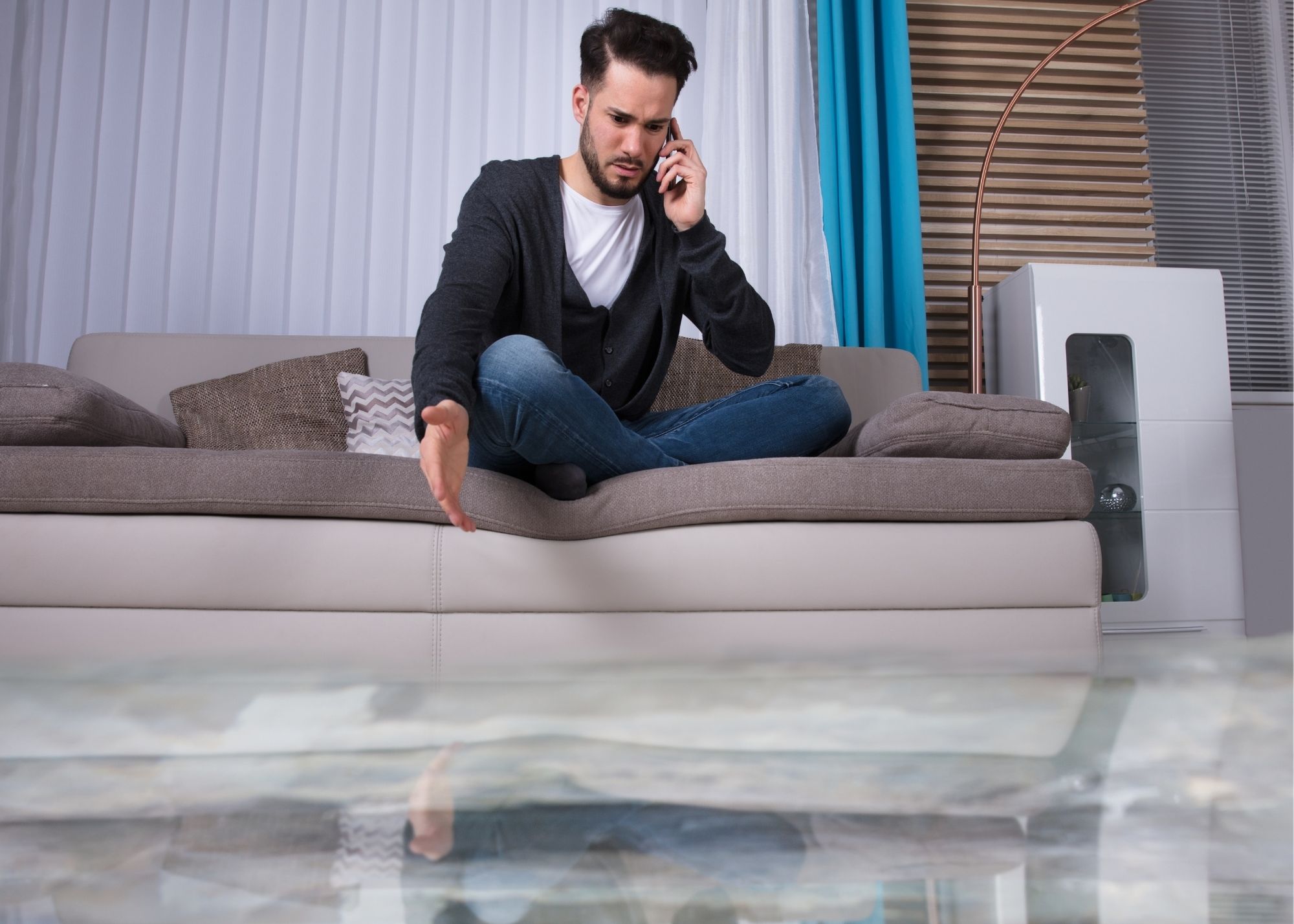 Homeowner calling for help while standing water floods an Austin living room