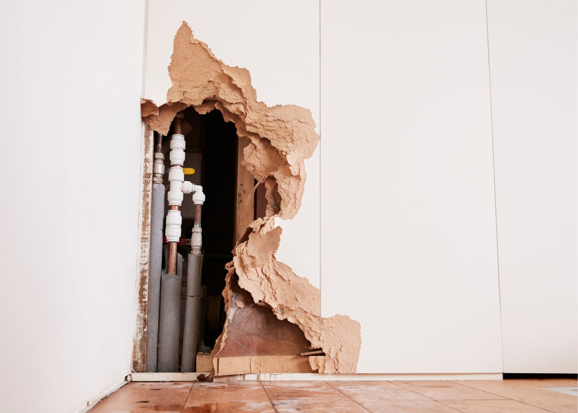 Exposed pipes in a wall after a burst pipe in an Austin, TX home
